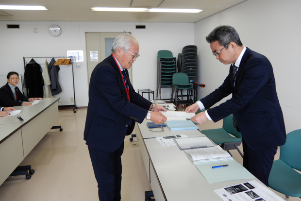 神戸地方法務局職員に要請文を手渡す坂本委員長（左）（3月14日・神戸市）