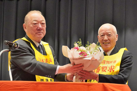 今期で引退する坂本副委員長に西島委員長が花束を贈呈（3月2日・東京）
