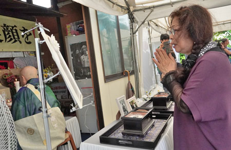初盆供養で焼香し、石川一雄さんの遺影に手を合わせる石川早智子さん（８月１１日・埼玉県狭山市）
