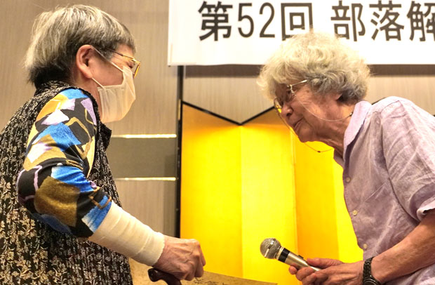 表彰状を手渡し、受賞者に声をかける鎌田慧・実行委代表（7月25日・大阪市）